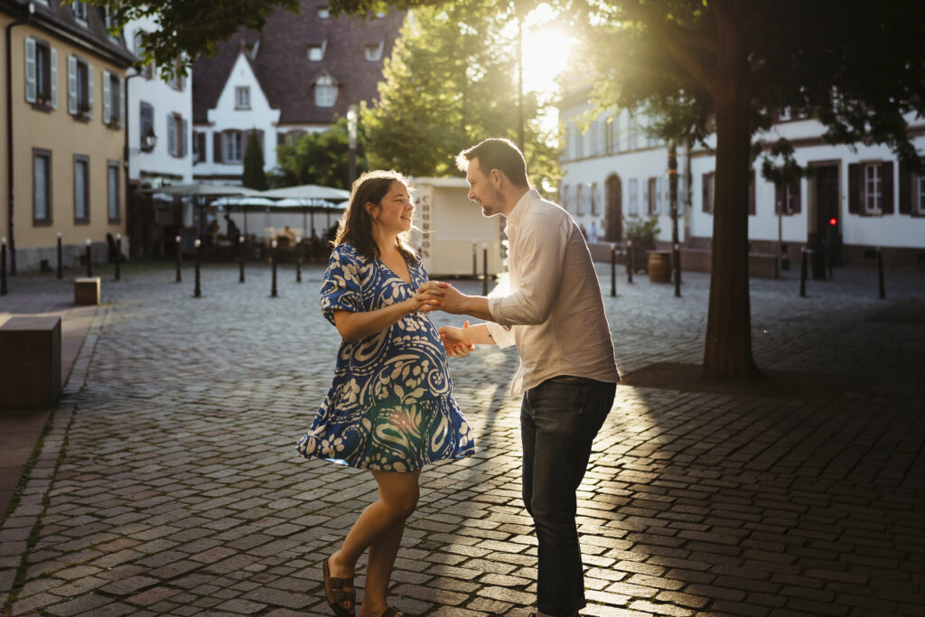 Photographe grossesse et maternité à Melun. Photo d'un couple de parents amoureux qui dansent dans les rues de Melun pendant une séance grossesse en Seine et Marne
