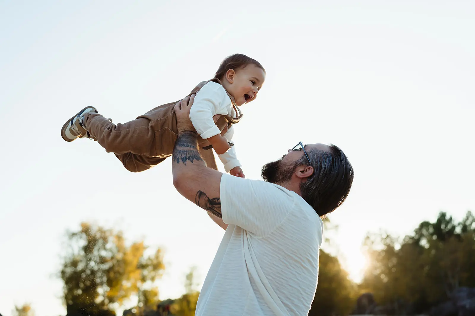 Image spontanée d'un papa qui joue avec son bébé pendant une séance photo en famille à Fontainebleau