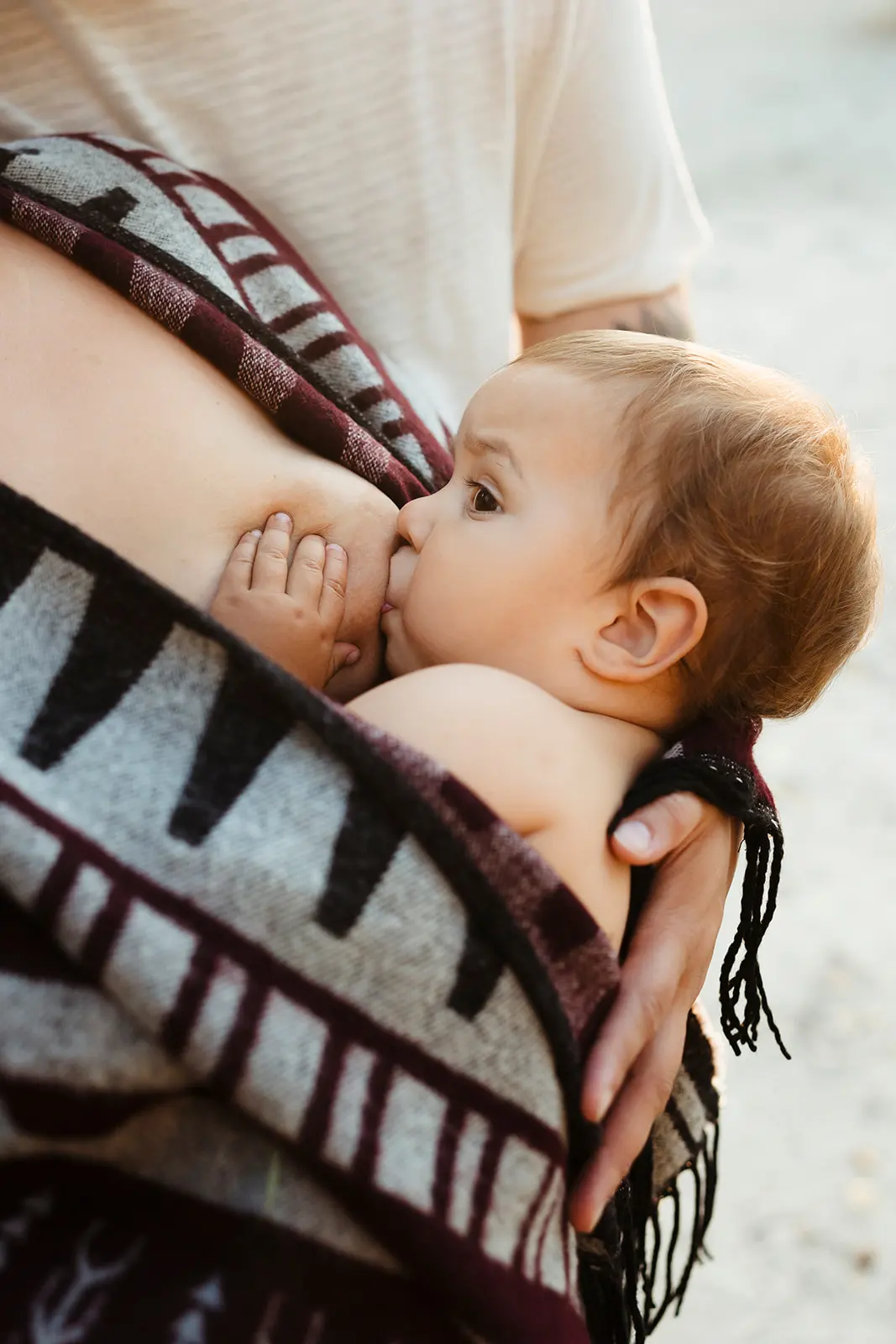 Portrait en couleur d'un bébé pendant un moment de tendresse avec sa maman lui donnant le sein pendant une séance photo allaitement à Fontainebleau
