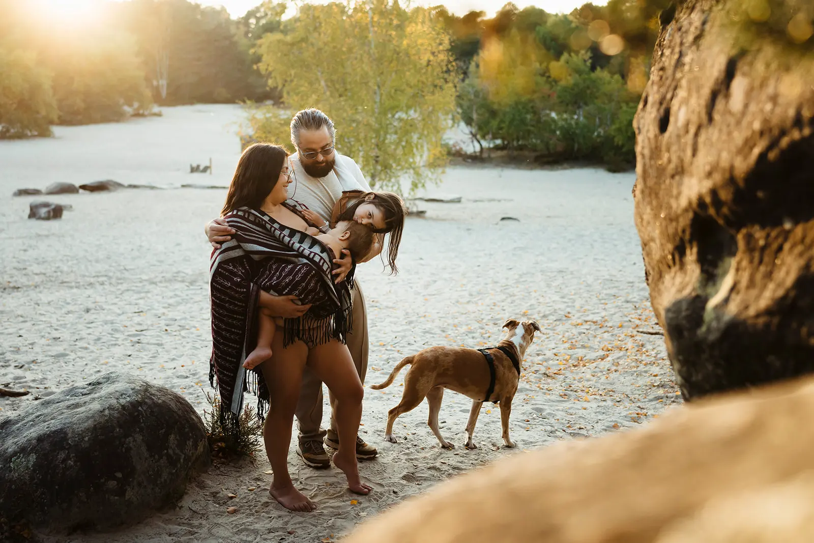 Photo de famille au coucher du soleil dans la forêt de fontainebleau pendant une séance photo allaitement