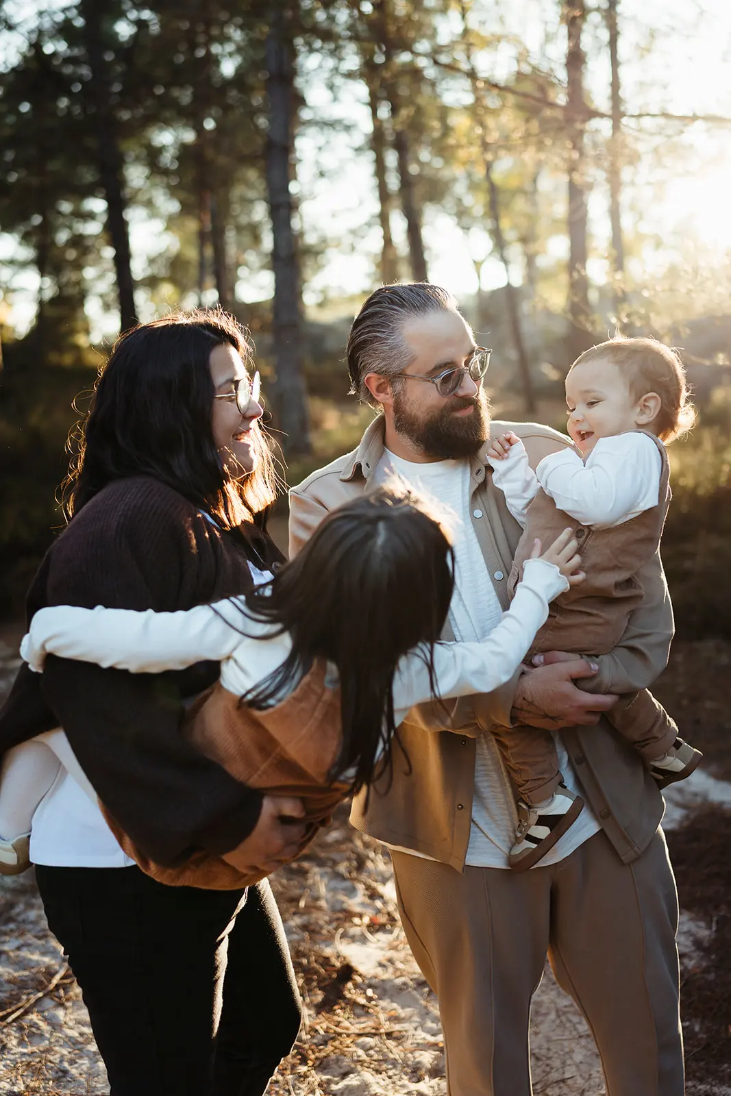 Photo colorée d'une famille dans un moment de complicité pendant une séance photo famille en forêt de Fontainebleau