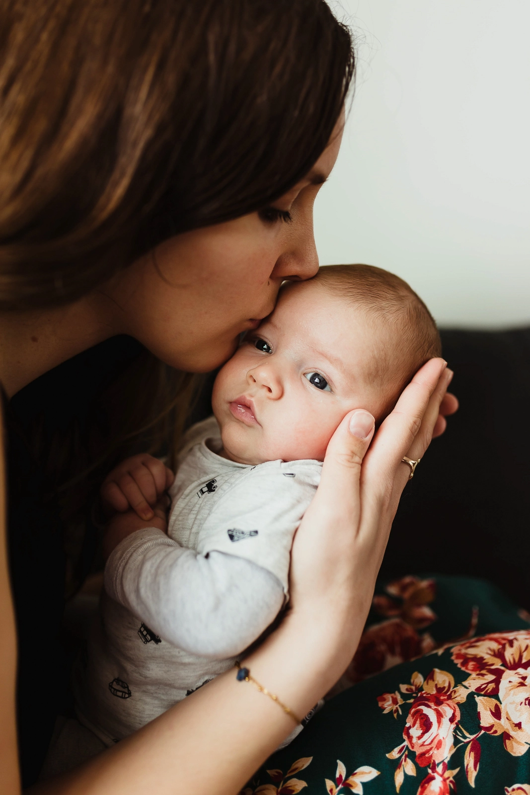 Photo en couleur d'une mère embrassant son nouveau-né pendant un reportage photo de naissance à domicile en seine et marne