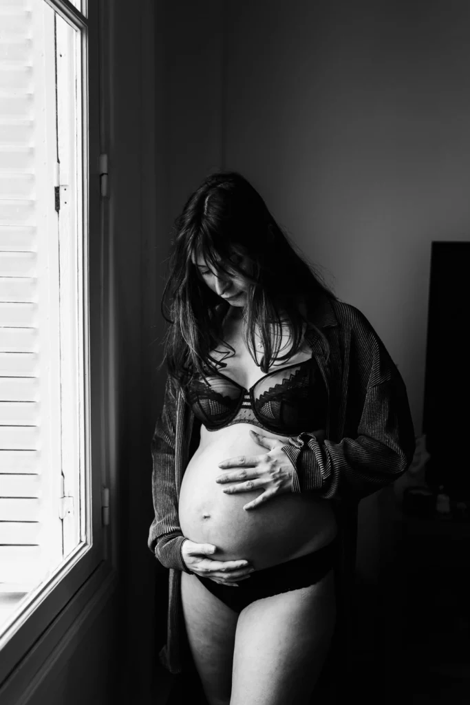 Portrait noir et blanc d'une femme enceinte pendant une séance grossesse à domicile à melun