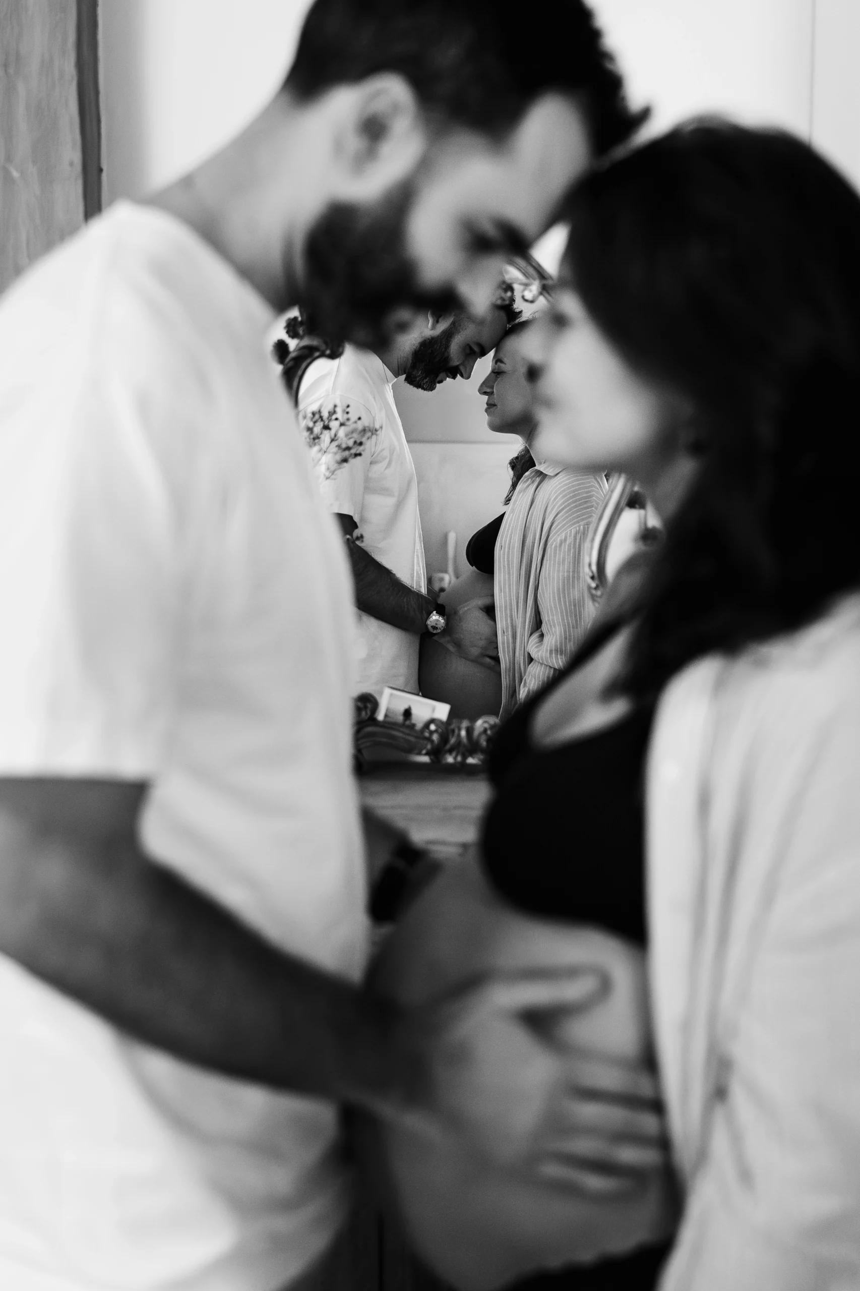 Photo d'un couple de futurs parents amoureux pendant une séance photo grossesse à domicile à Melun