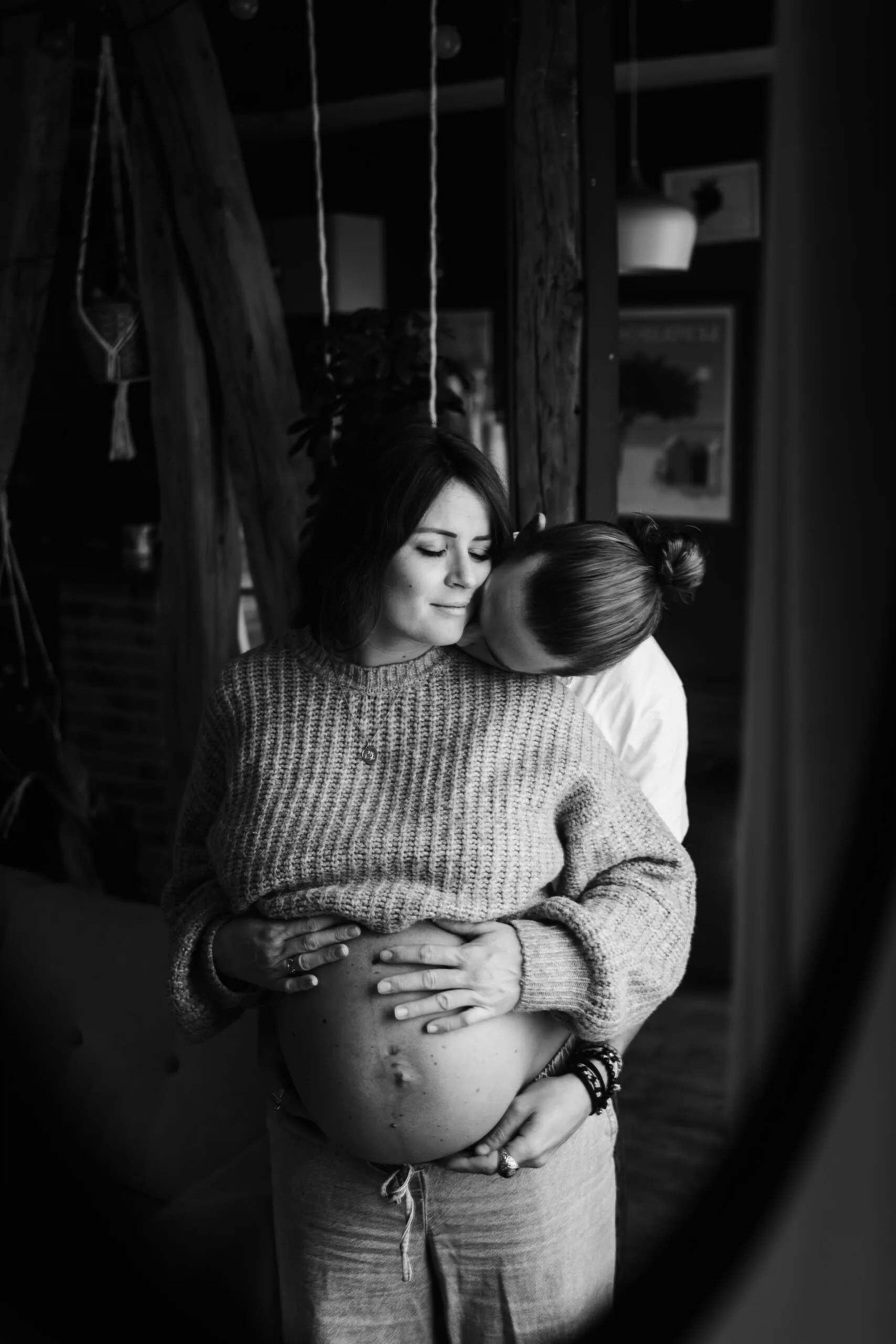 Couple de futurs parents se serrant dans les bras dans un moment complice pendant une séance photo grossesse à melun