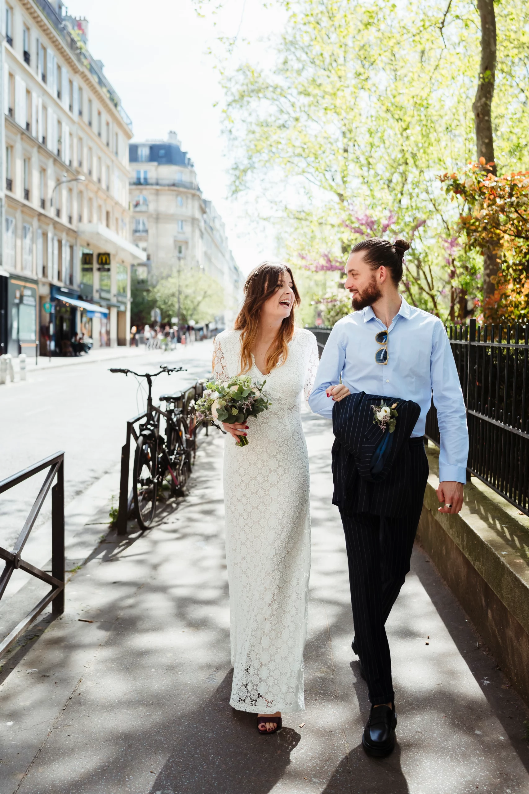 Couple heureux marchant en riant dans les rues de paris pour aller à un mariage civil