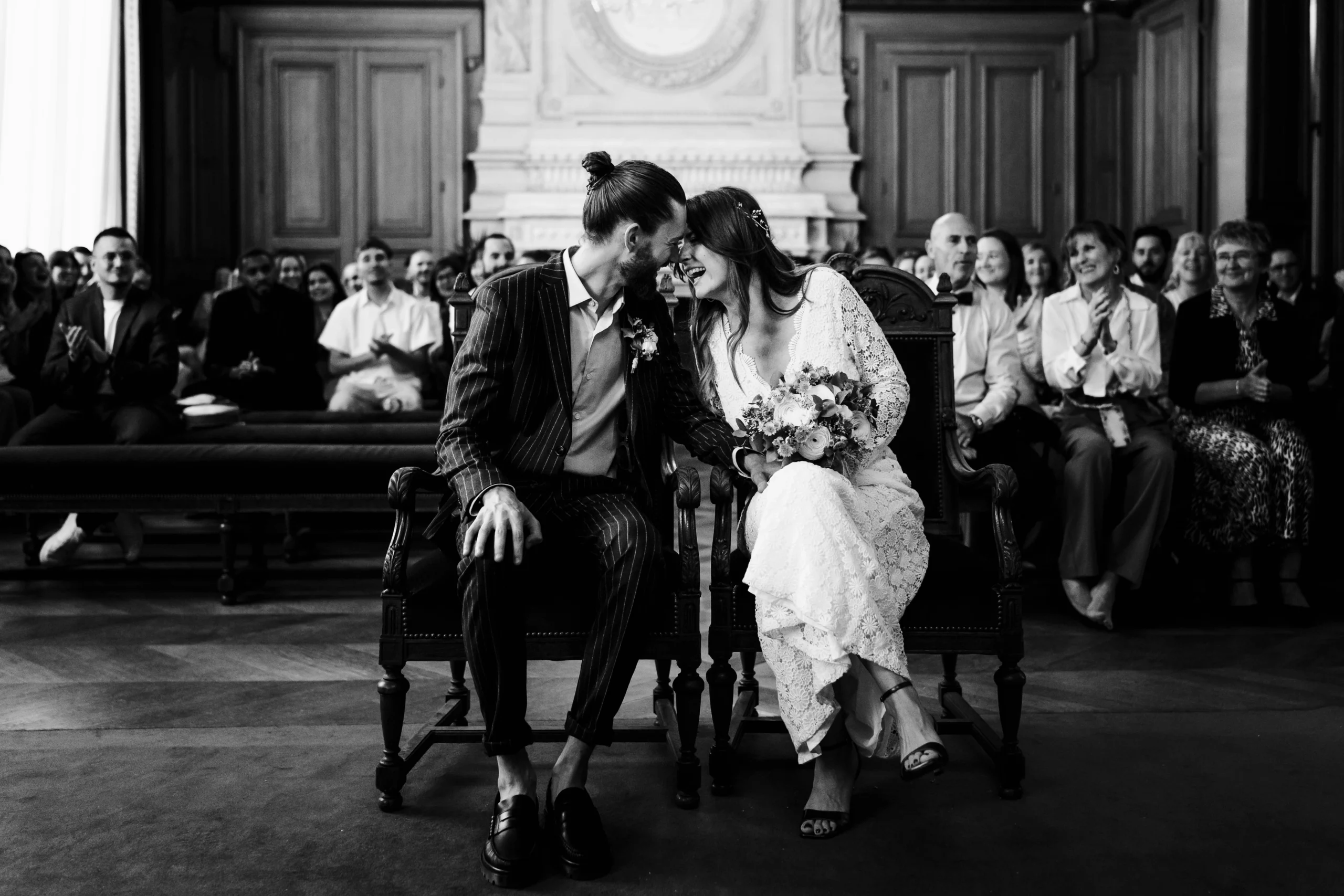 Couple de mariés riant pendant leur cérémonie de mariage civil à la mairie du 11ème arrondissement de paris