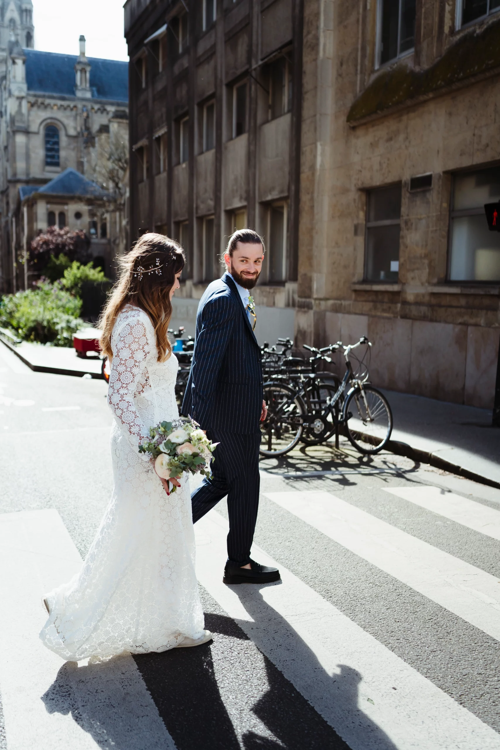 couple de mariés marchant dans les rues de paris pendant leur mariage civil à la mairie du 11ème arrondissemnt