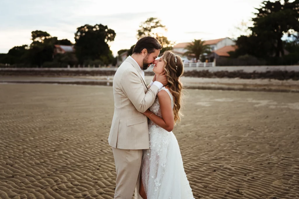 Photo colorée d'un couple de mariés au couché du soleil sur la plage pendant leur mariage sur l'ile d'oleron