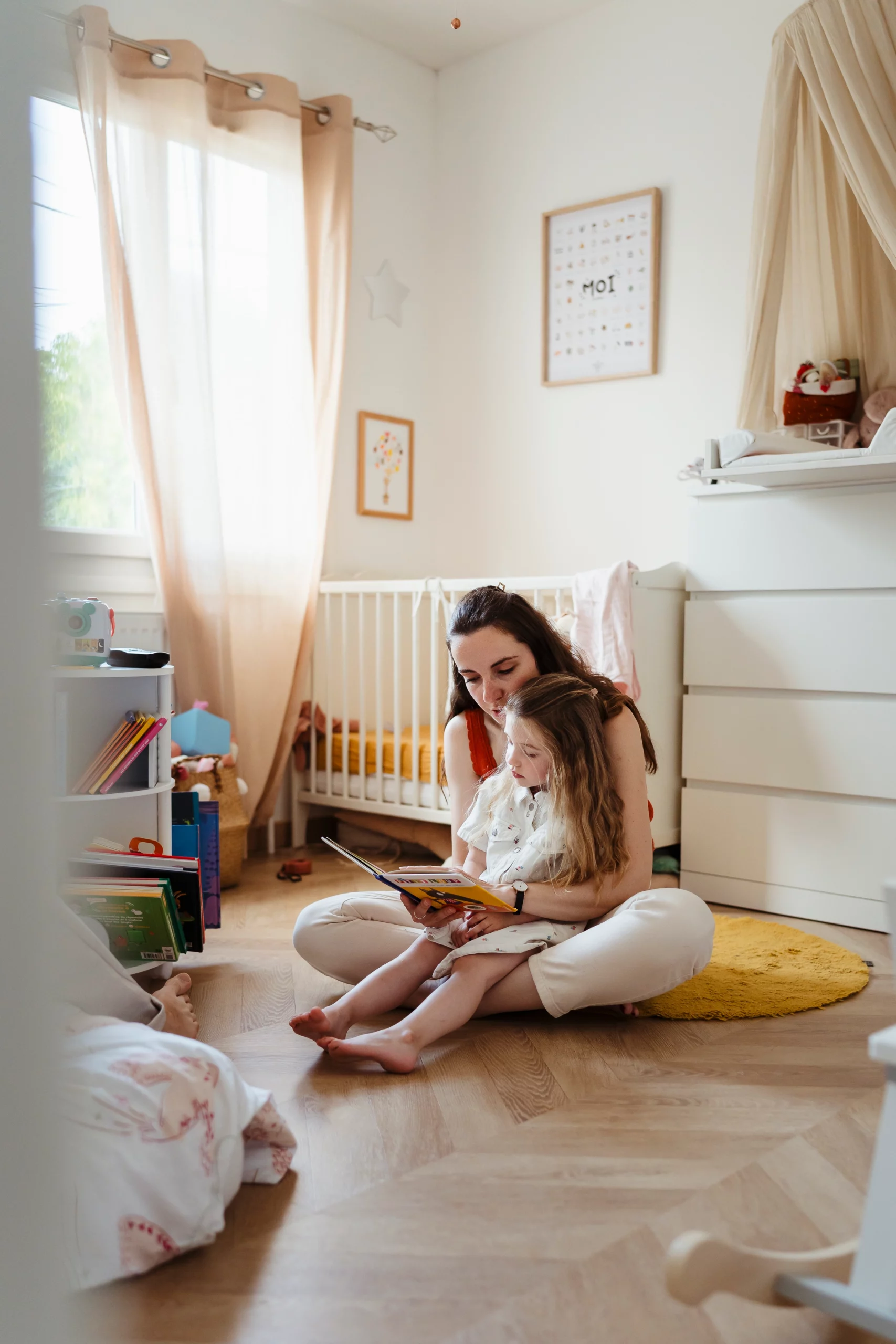 Photo d'une maman lisant une histoire à son enfant pendant une séance photo de famille a fontainebleau