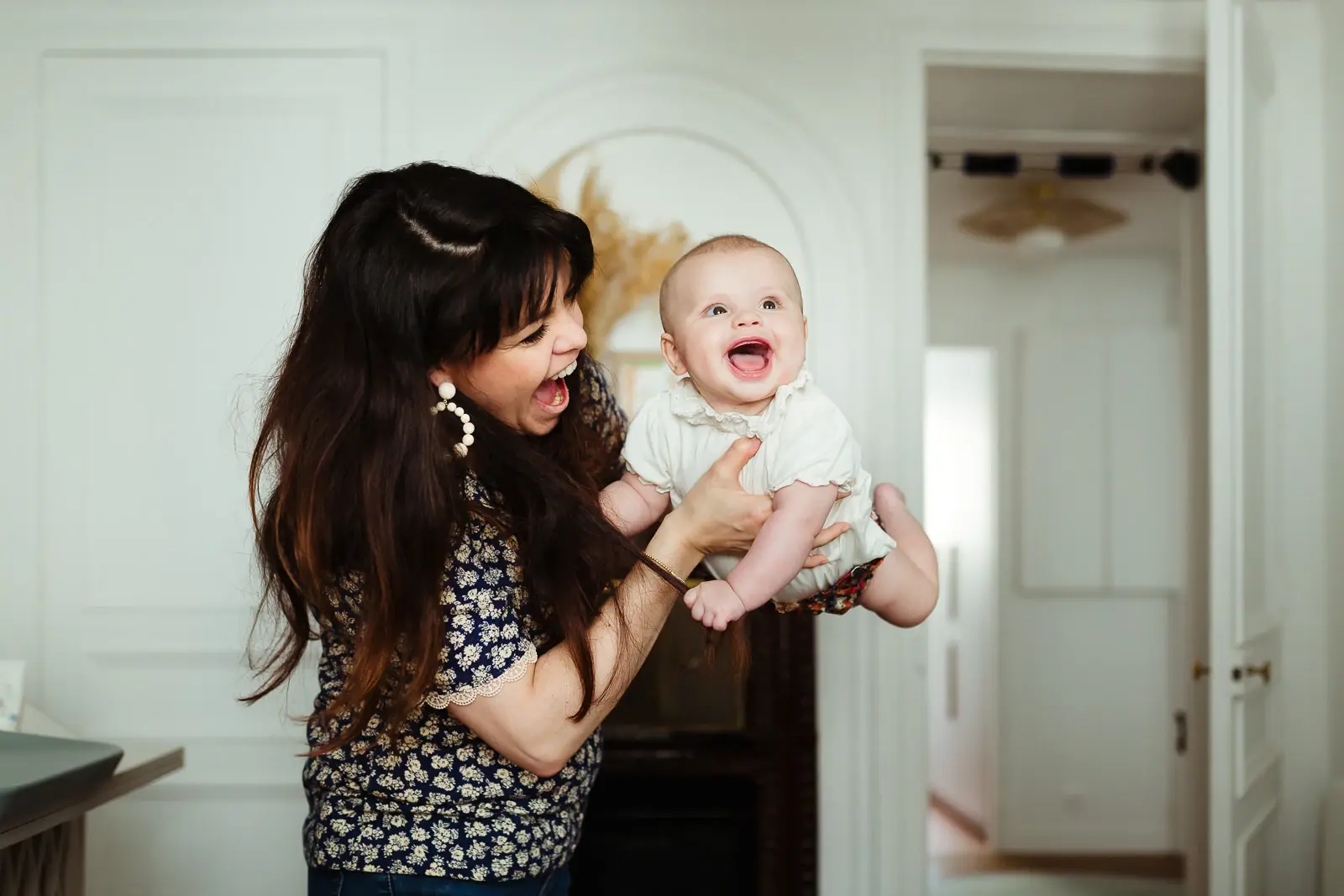 Photo naturelle et colorée d'un bébé joyeux avec sa maman pendant une séance photo de famille à fontainebleau