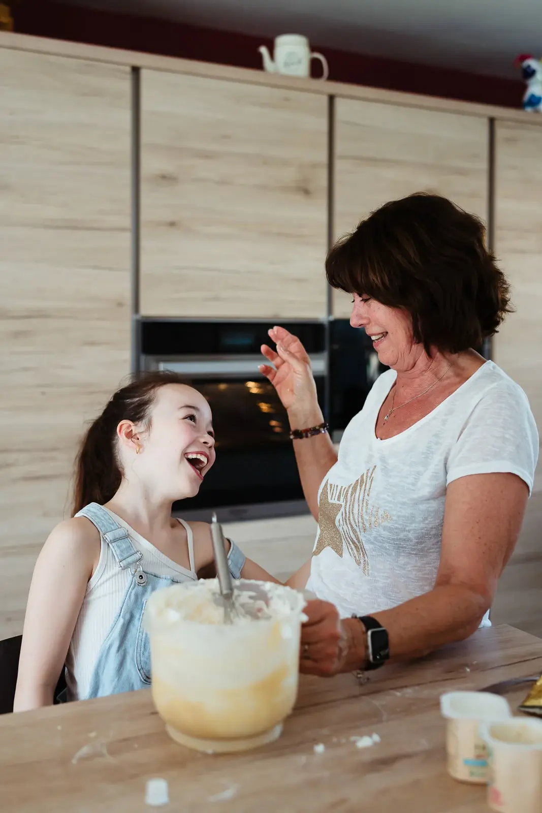 Une grand-mère et sa petite fille qui font de la cuisine pendant une séance photo famille en seine et marne