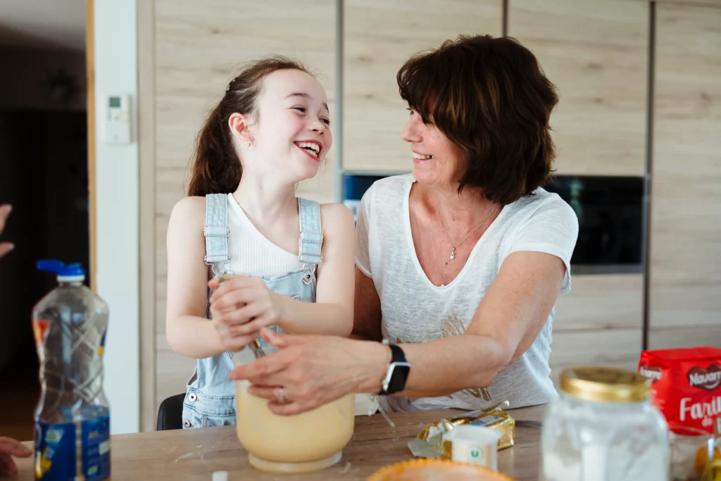 Une grand-mère et sa petite fille cuisinant ensemble pendant une séance photo de famille à fontainebleau