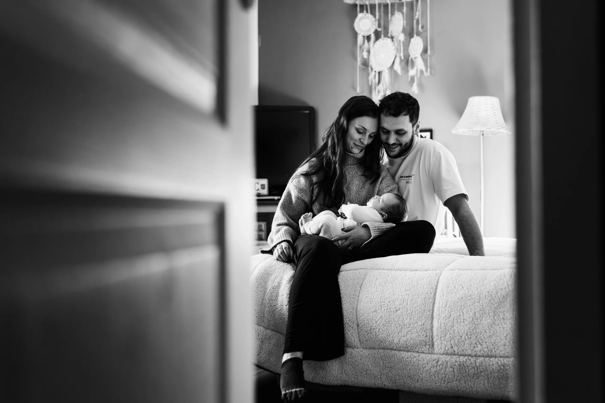 Portrait noir et blanc d'une famille profitant d'un moment câlin pendant une séance photo de famille à fontainebleau