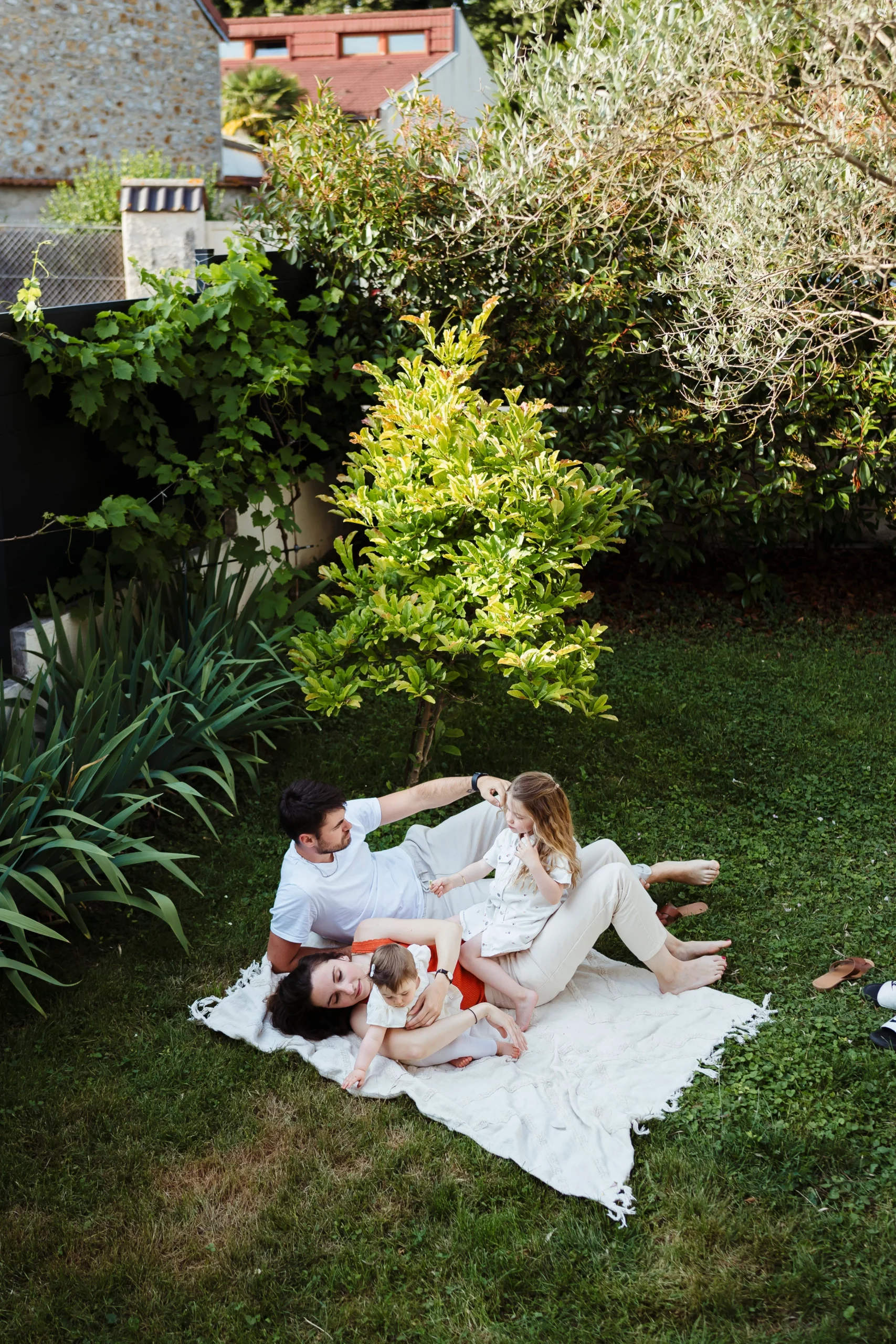 photo d'une famille jouant dans le jardin à fontainebleau pendant une séance photo de famille à domicile dans le 77