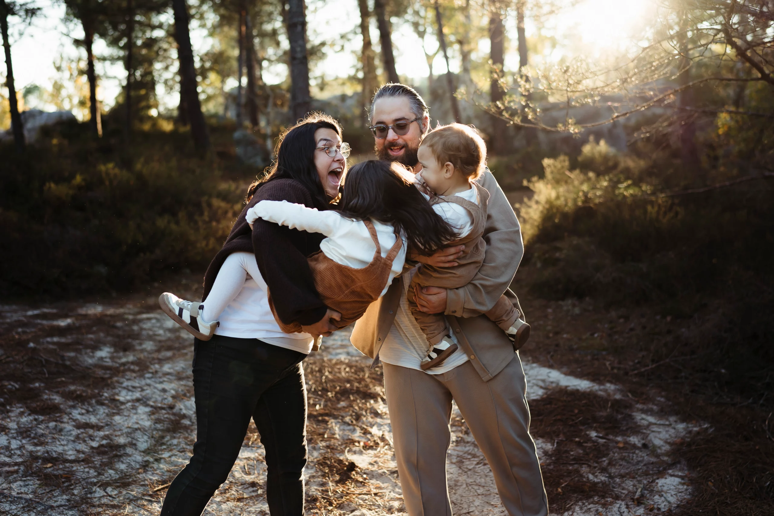 Une famille qui s'amuse en forêt de fontainebleau pendant une séance photo famille