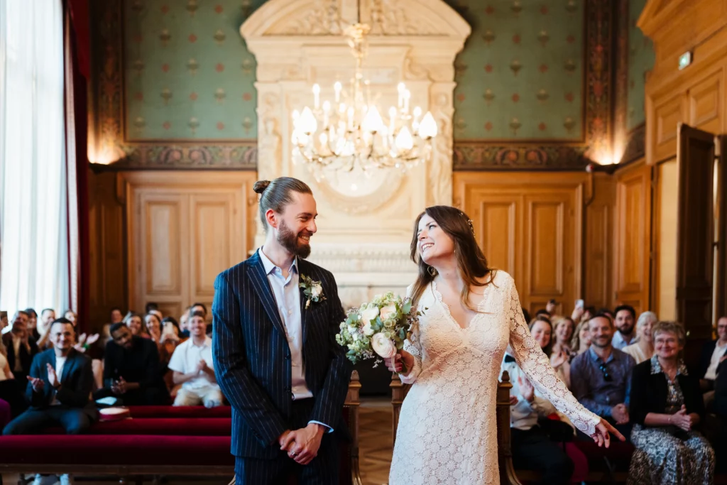Photo d'un couple de mariés joyeux et fun pendant un mariage civil à la mairie du 11è à Paris