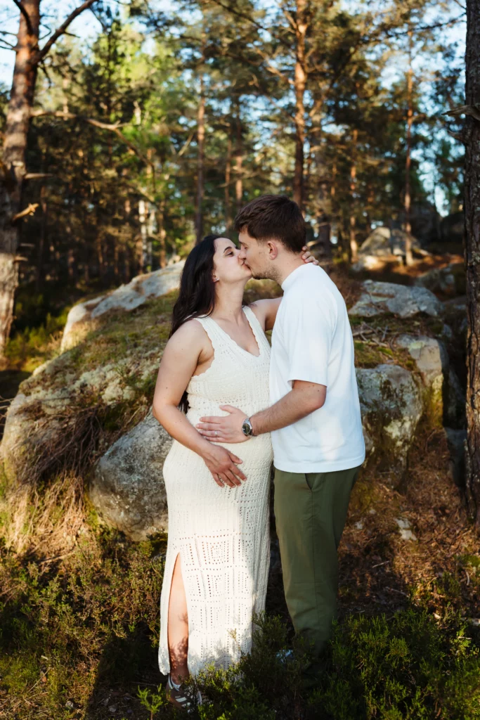 couple de futurs mariés qui s'embrassent pendant une séance engagement au coucher du soleil en forêt de fontainebleau