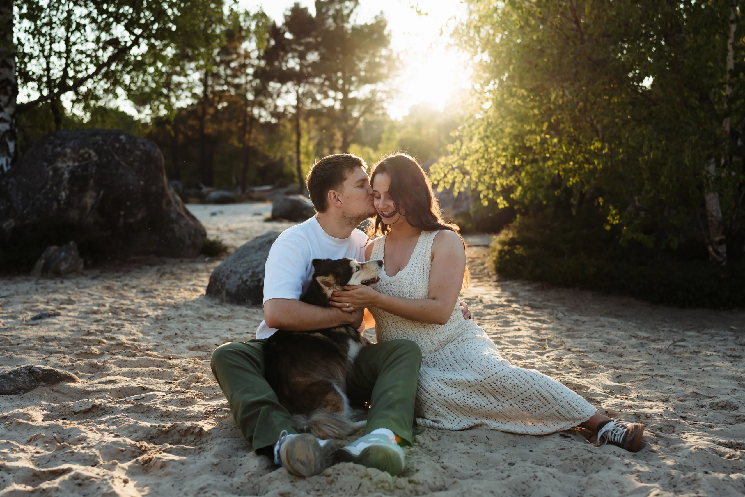 couple amoureux pendant une séance engagement avec un chien en forêt de fontainebleau