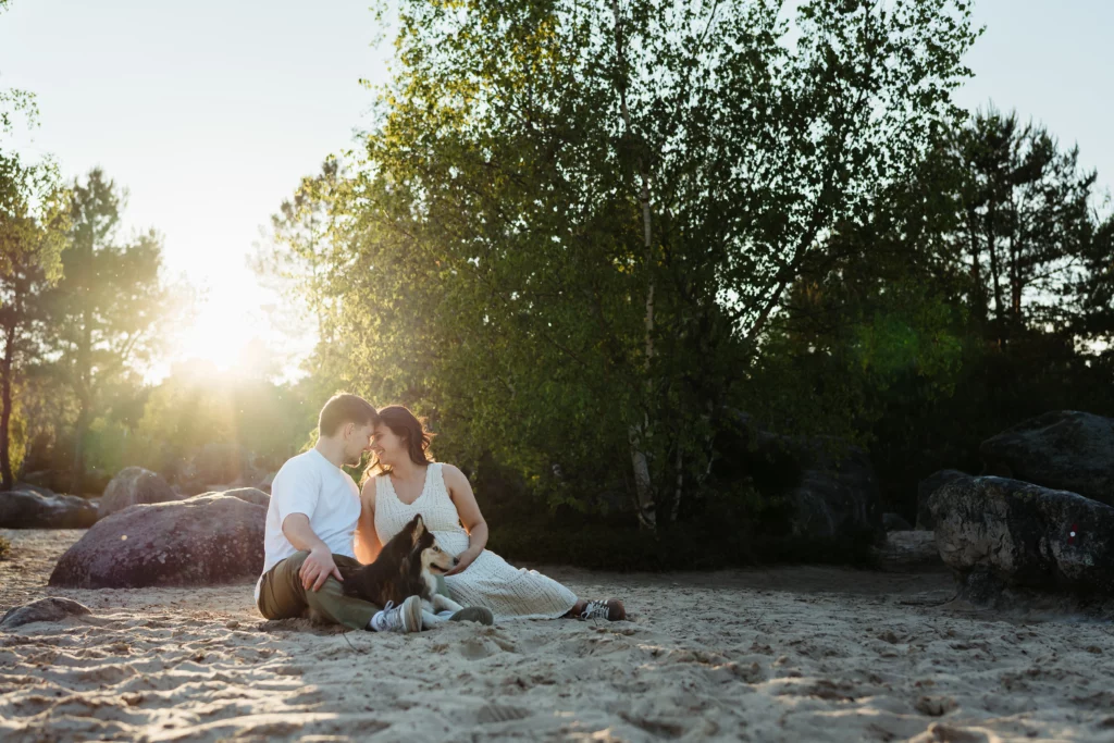 couple de mariés avec leur chien pendant une séance photo engagement au coucher du soleil à fontainebleau