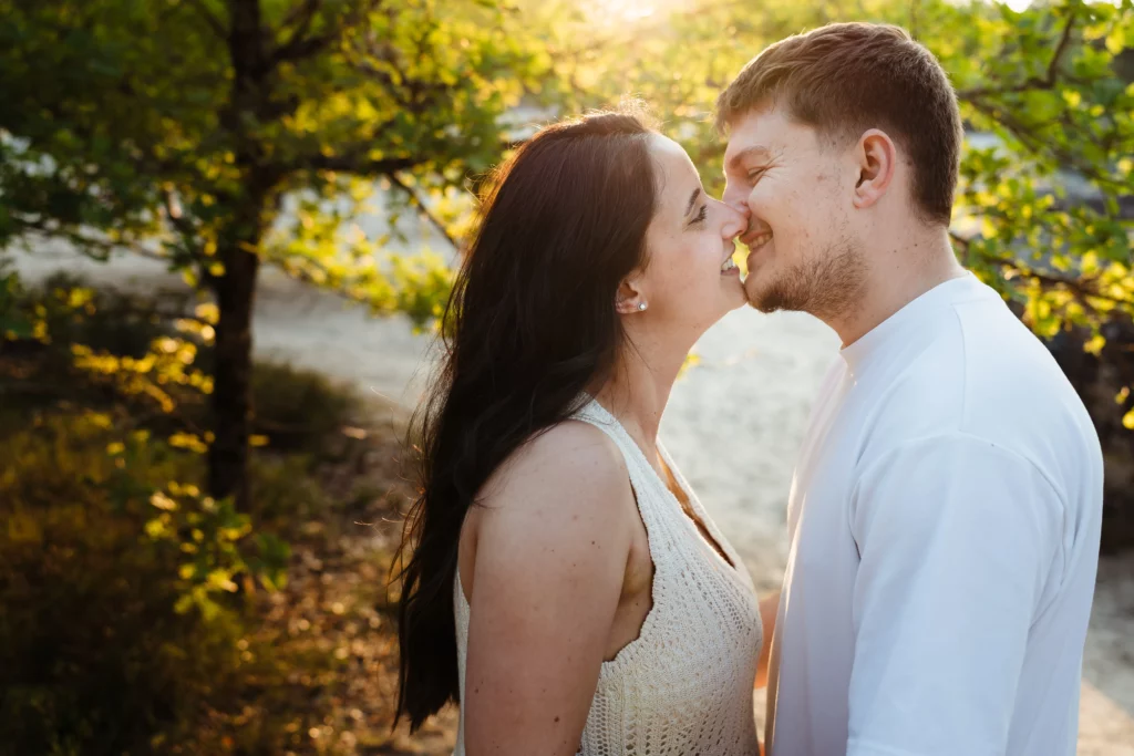 Photo d'un couple amoureux qui s'embrasse pendant une séance photo d'engagement en forêt de fontainebleau