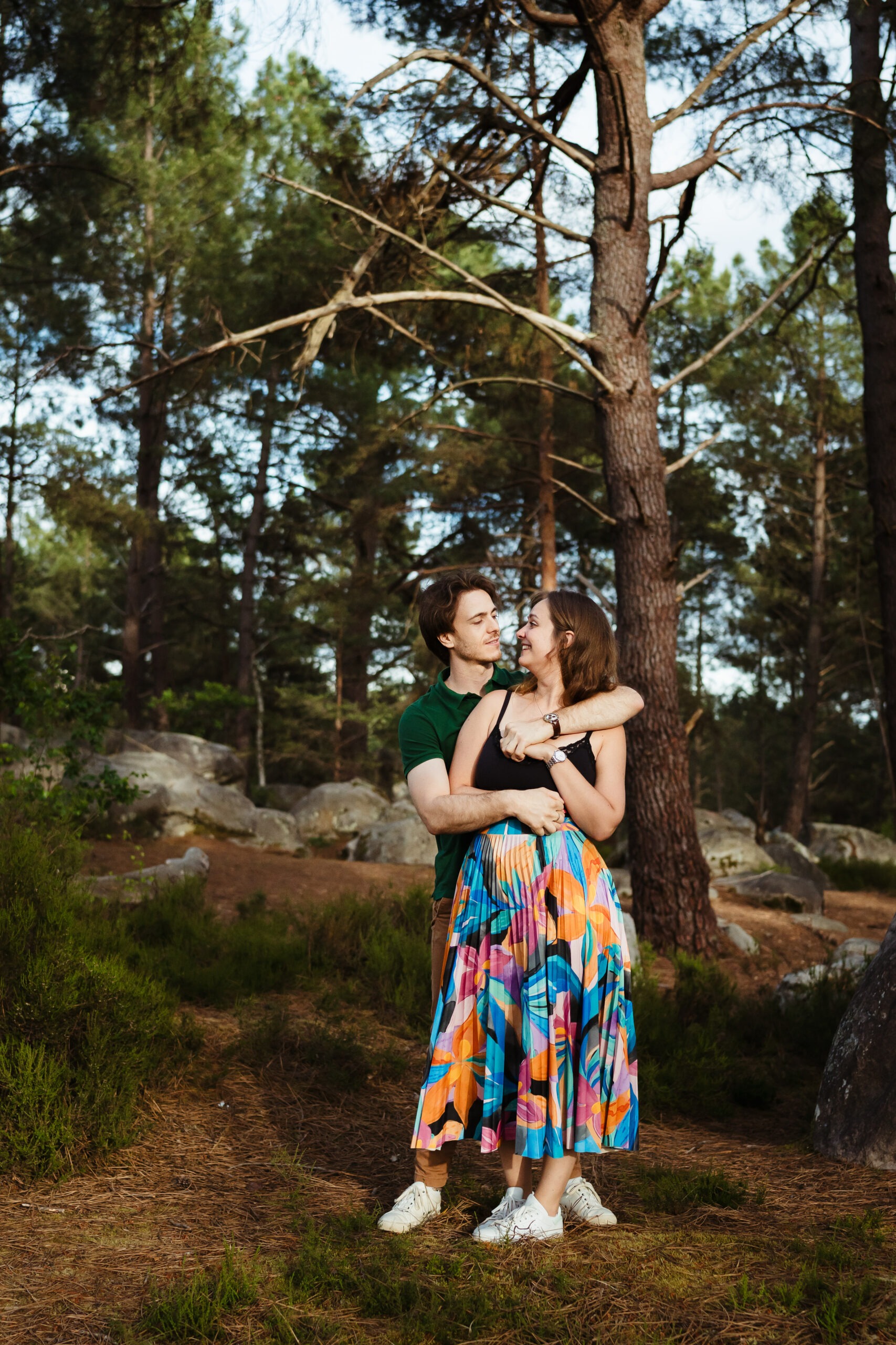 Moment complice d'un couple pendant une séance photo en forêt de Fontainebleau
