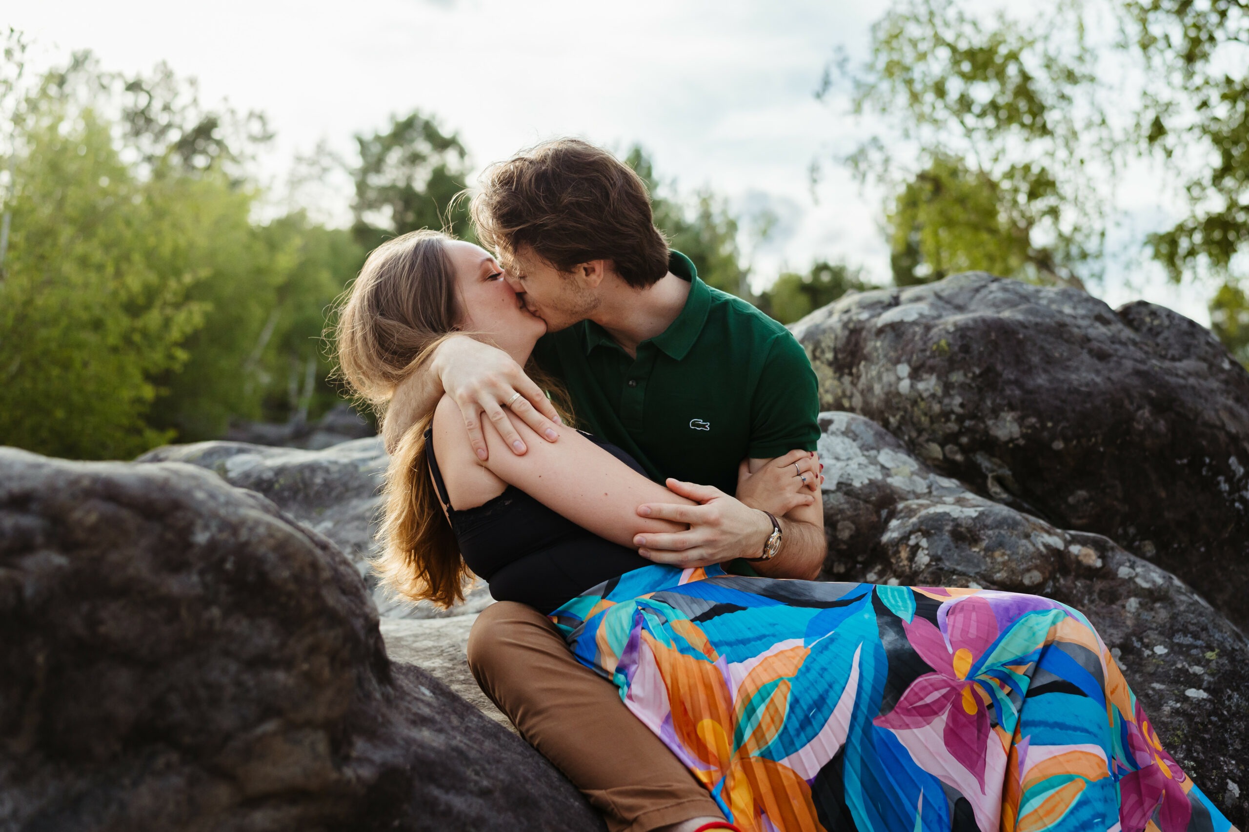 Amoureux qui s'embrassent sur les rochers de Fontainebleau pendant une séance photo couple