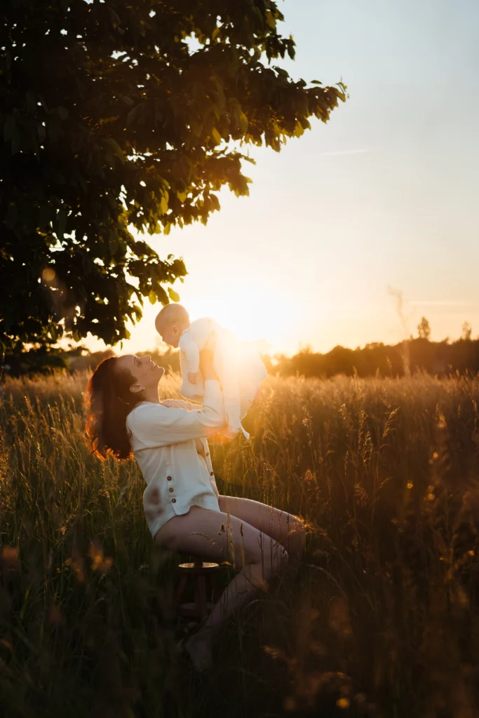 Maman et son bébé au couché du soleil pendant une séance photo allaitement à Fontainebleau